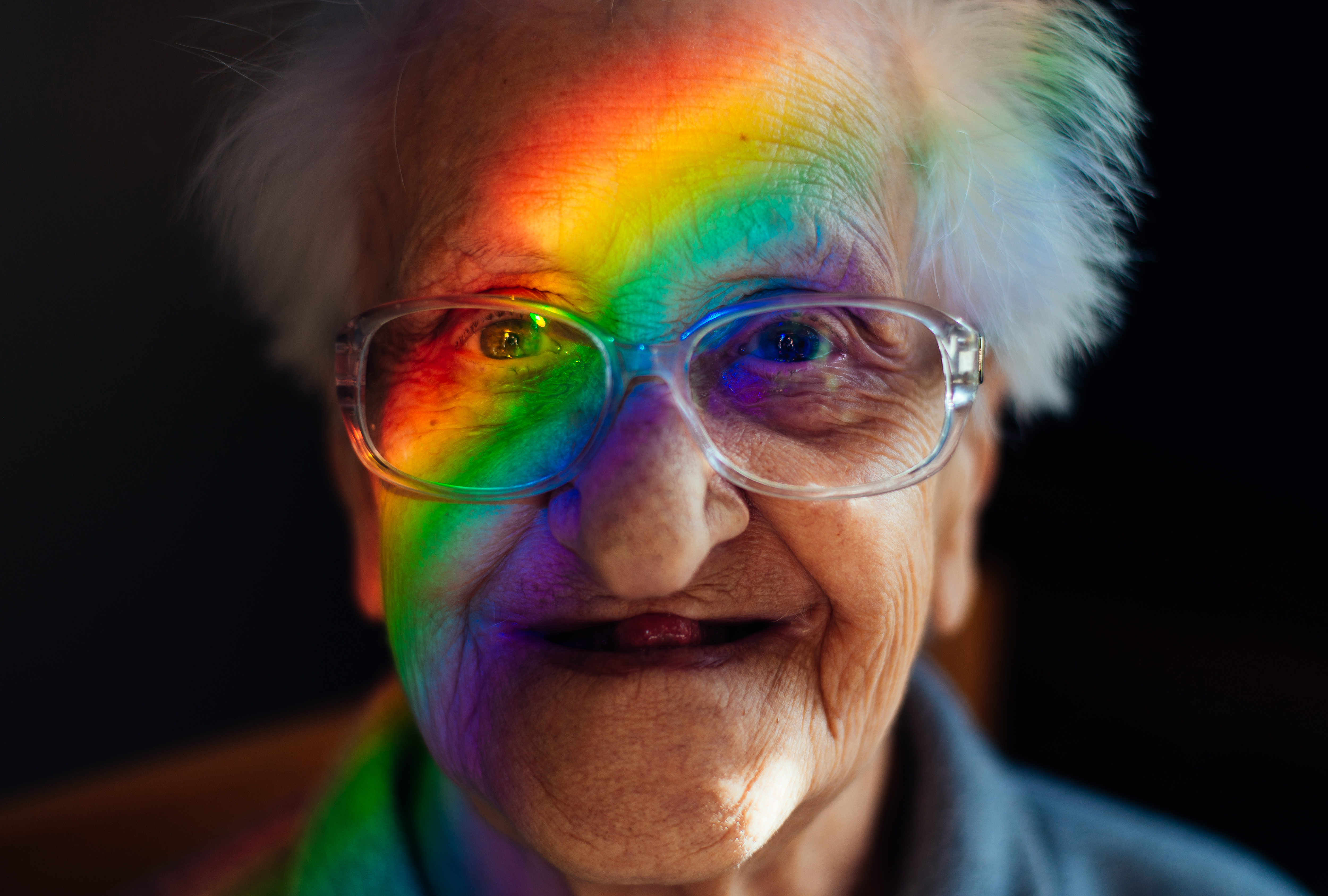 ältere Dame mit Regenbogenfarben im Gesicht